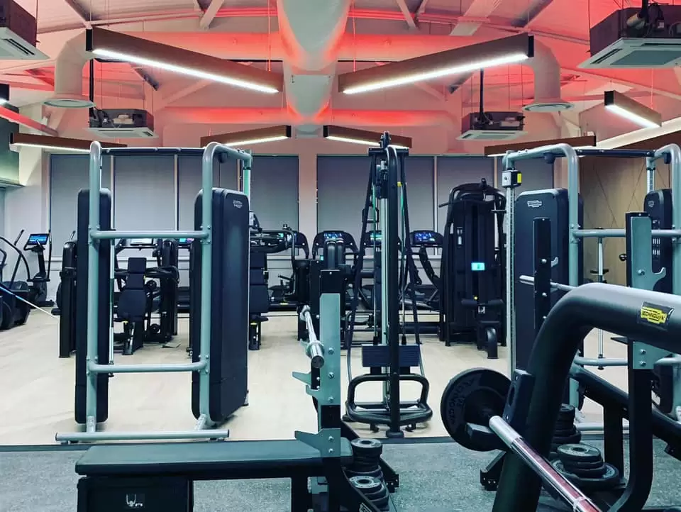 A photo of the Lensbury gym in Teddington completely empty, with a full range of high end equipment and where leisure centre classes can take place. The health and fitness centre is open 6:00-22:00 Monday to Thursday, 6:00-21:00 Friday and 7:00-20:00 on weekends.