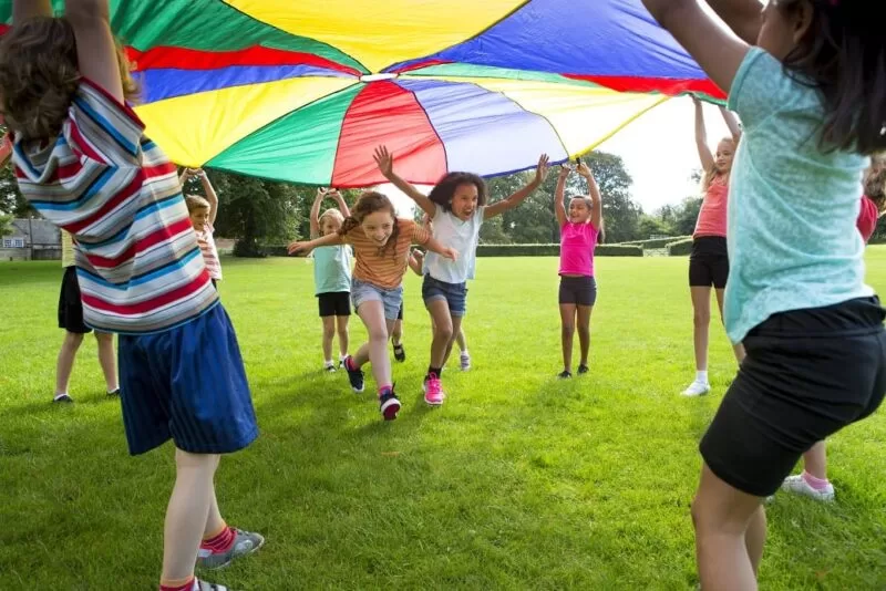 Kids playing under a tent at The Lensbury club in teddington, running underneath the lifted tent