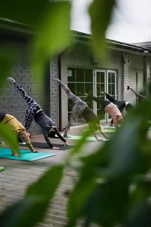 A group of individuals enjoy yoga in the ground of The Lensbury in Teddington, classes which are included in their Lensbury membership cost
