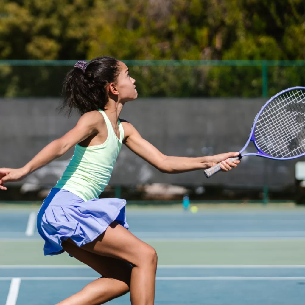 Young girl playing tennis on artificial courts at The Lensbury Club