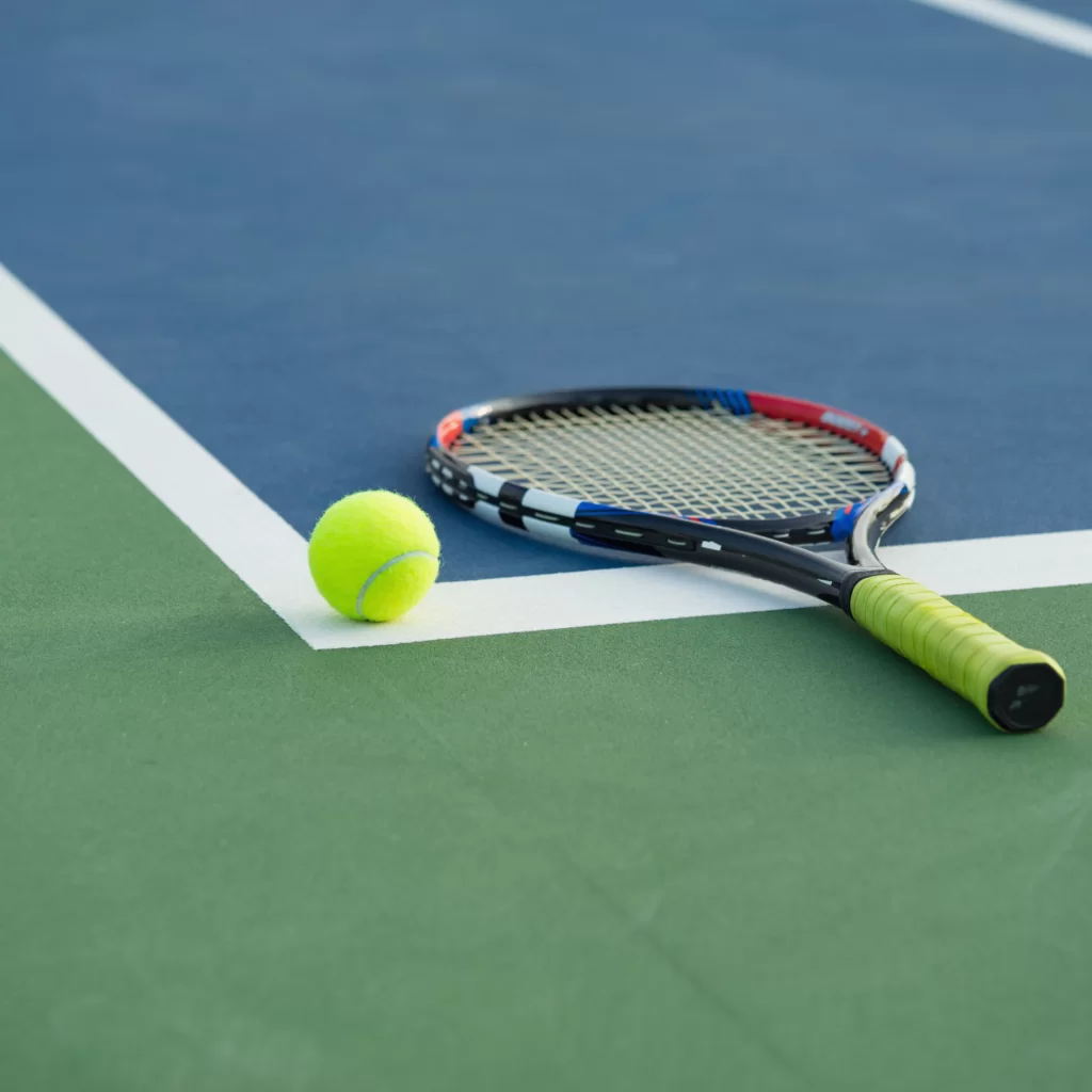 Tennis racquet and ball on court at The Lensbury Club.