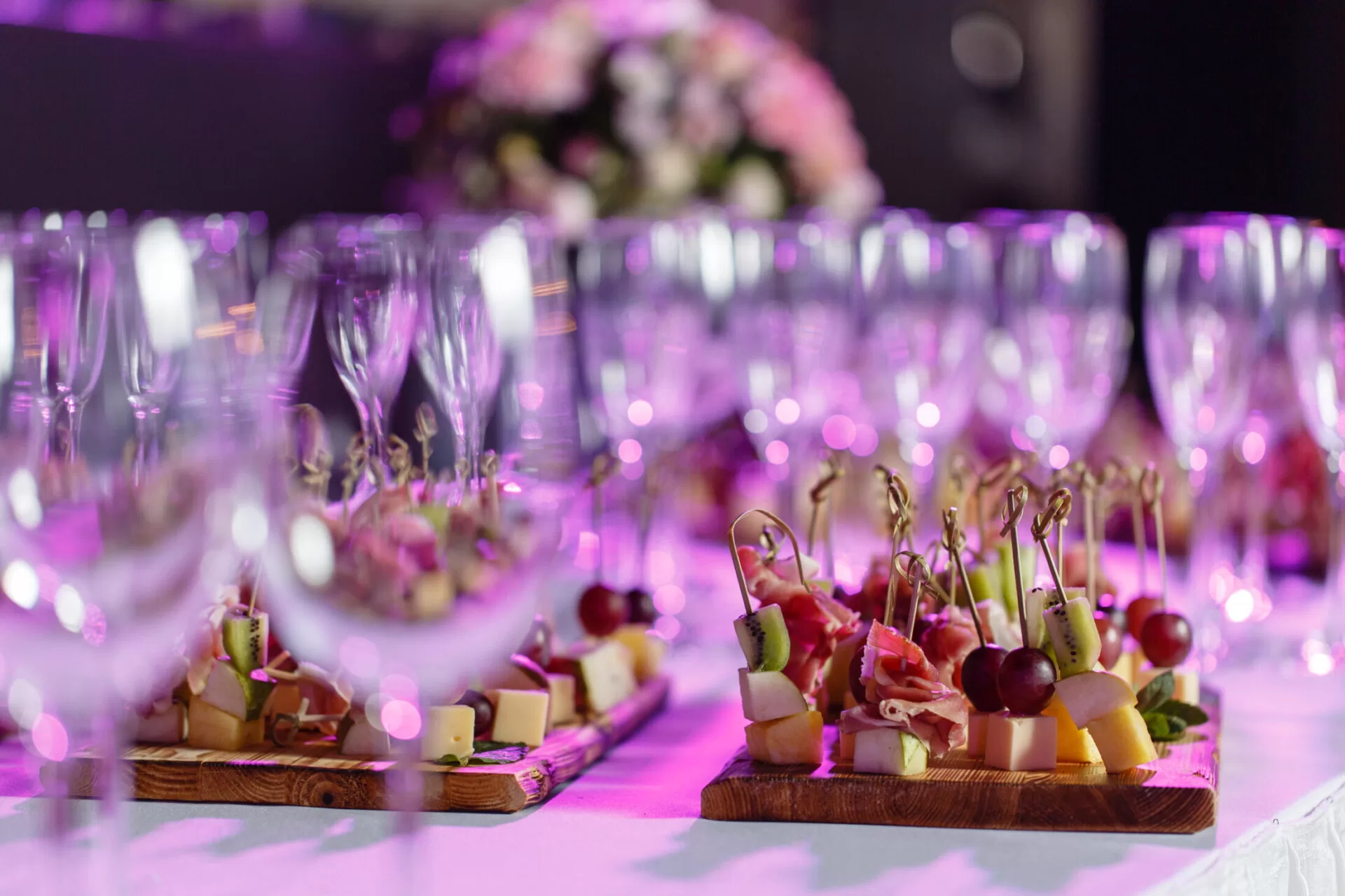 solemn happy new year banquet. Lot of glasses champagne or wine on the table in restaurant. buffet table with lots of delicious snacks. canapes, bruschetta, and little desserts on wooden plate board