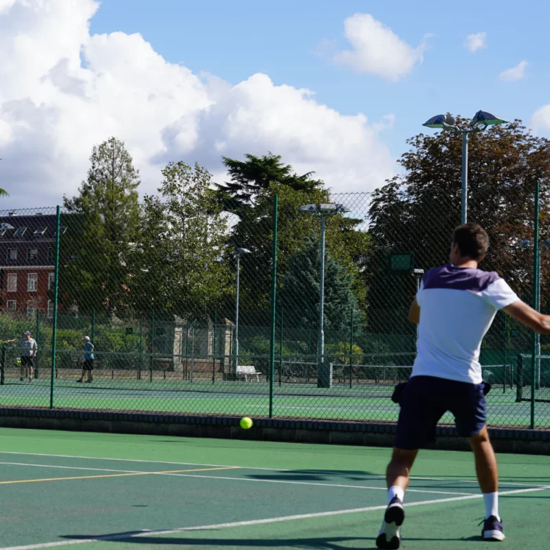 Man playing Tennis at The Lensbury Club in Teddington, London