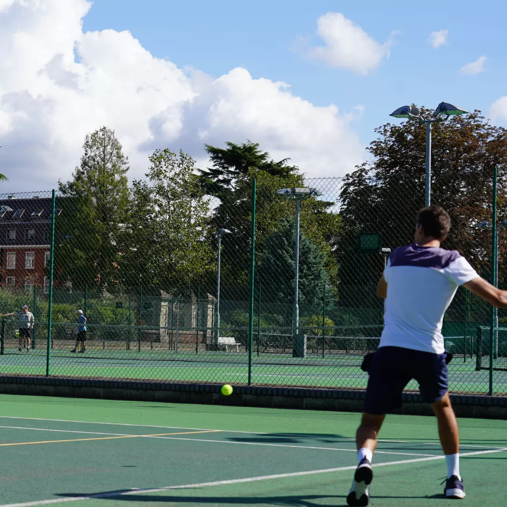 Man playing Tennis at The Lensbury Club in Teddington, London